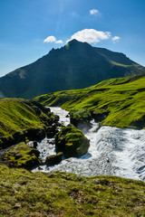 Famous Skogafoss Waterfall, Iceland on sunny summer day and blue sky, view to the river from above