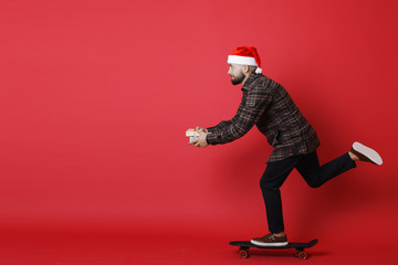 Bearded guy with Christmas gifts riding skateboard