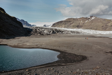 Rocky scene to Skaftafellsjokull glacier with water, in Skaftafell, Iceland in summer, vintage or retro look with grain