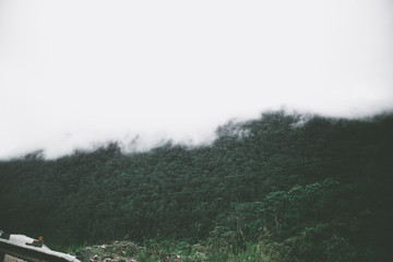 View of sky road over top of mountain with fog and green jungle after raining in morning, Da Lat, Vietnam. The transportation road across mountain.