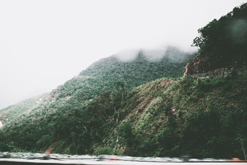 View of sky road over top of mountain with fog and green jungle after raining in morning, Da Lat, Vietnam. The transportation road across mountain.