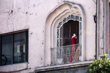 Fototapeta na wymiar Vestido rojo en maniquí en ventana de balcón