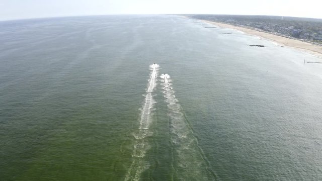 Aerial drone shot over two jetskis racing out into the open ocean off the coast of New Jersey.