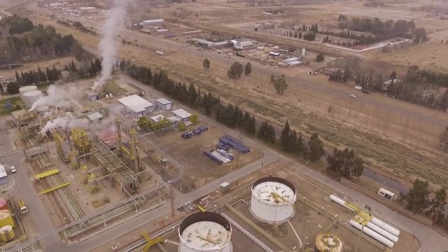 Aerial. Oil refinery and road, cars passing by.