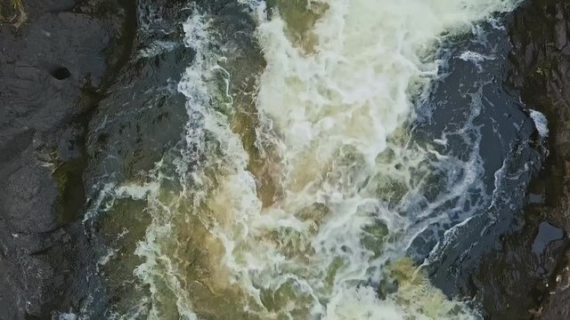 Full water stream with foam and rocks