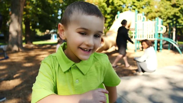 Little boy in bright green shirt being silly on playground