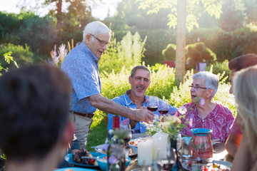 during a family bbq a son toasts with his parents