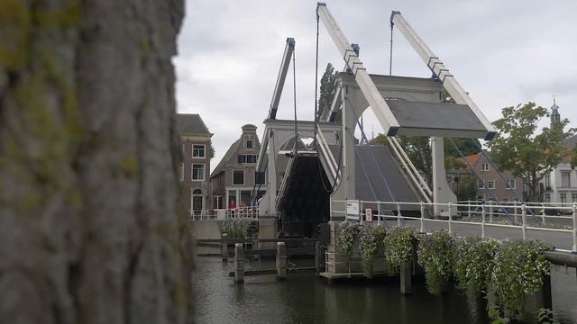 A Picturesque Bridge in Amsterdam Opening and Letting Through a Boat