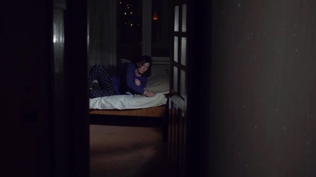 Girl half asleep heard a noise in the apartment and went to look with flashlight,concept thief