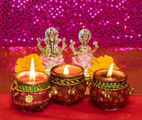 Diwali Background Showing Lit Lamps Against Idols of Deities Lakshmi and Ganesh