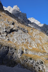 Sun and cloud shadows on mountain with autumn colors in German Alps