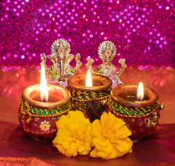 Diwali Background Showing Lit Lamps Against Idols of Deities Lakshmi and Ganesh