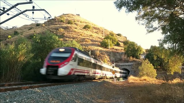 Alora, Spain - September 14, 2018: Alora to Malaga commuter train emerging from tunnel on electric track near Alora Andalusia