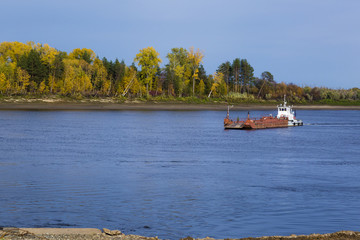 Boat on the river with a barge