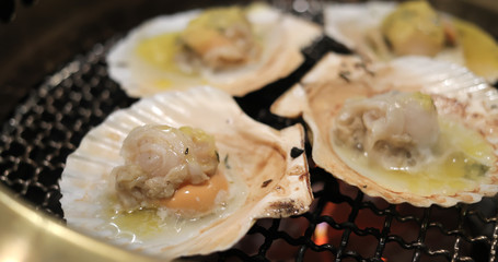 Scallop on metal net barbecue in restaurant