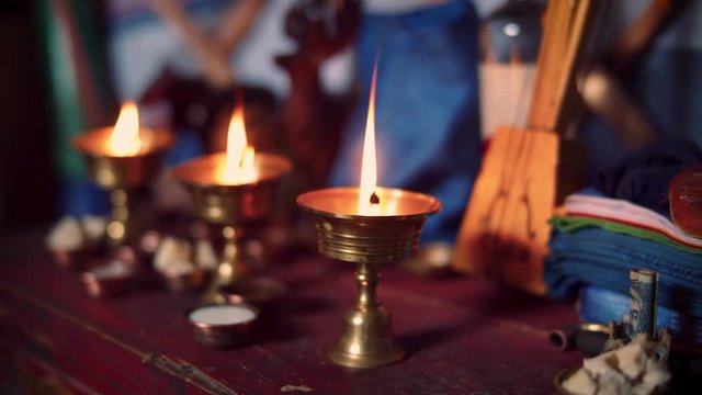 Set of three lights behing a Mongolian Shaman performing a blessing, praying or offering, during a ceremony in a ger, West Mongolia