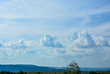 Landscape with beautiful large blue and white clouds on a blue sky on a sunny day