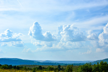 Fototapeta premium Landscape with beautiful large blue and white clouds on a blue sky on a sunny day