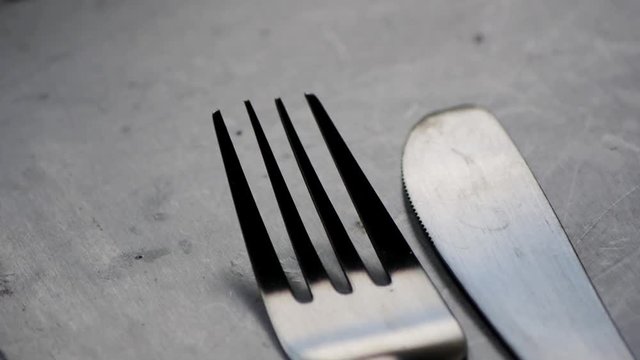 fork being placed down next to a knife, ready for food