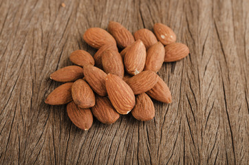 Almond pile on wood background in vintage tone