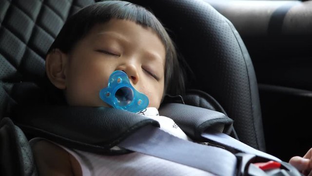 cute child sleeping in car seat