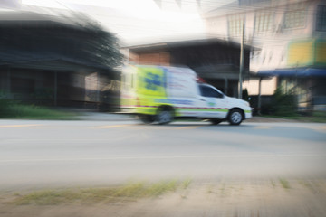 The blurred image of ambulance running at speed in local Thailand.