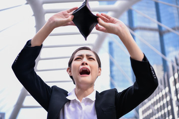 Concept of unemployed. Asian businesswoman is opening empty wallet. Young business woman is...