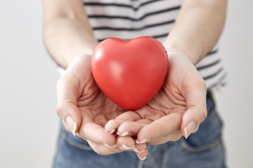 Young woman hand showing red heart