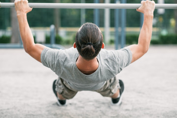 beam pull ups. sport and fitness. man exercising outdoors. chest muscles training.