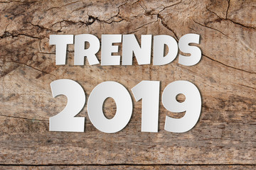 Paper word of TRENDS 2019 word on old wooden background