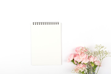 Flowers and a notepad on the white background