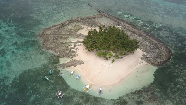 Aerial pedestal down tilting up shot of sandy Guyam Island, Siargao, the Philippines