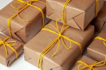Gift boxes in festive packaging with golden yellow bows. Delivery of gifts by the postal cargo service. Concept of New Year, birthday, valentine's day, holiday