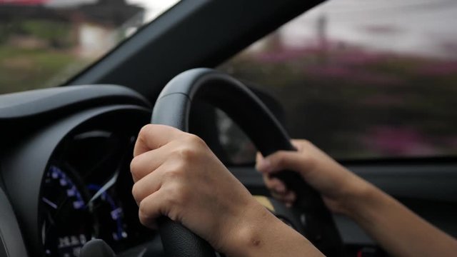 one person driving car in country road, hand control steering wheel