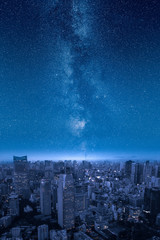 Stars of the milky way over big city skyline at night