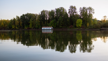 Obraz premium Columbia river in autumn colors. Boat docking station at the opposite shore.