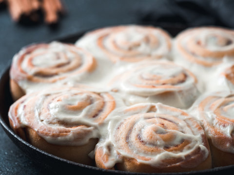 Idea and recipe pastries - perfect cinnamon rolls with topping in skillet. Close up view of vegan swedish cinnamon buns Kanelbullar with pumpkin spice,topping vegan cream cheese. Copy space for text