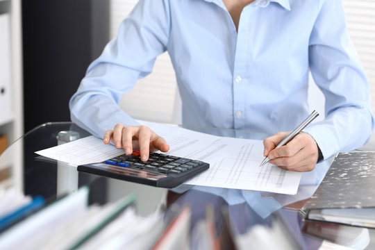 Bookkeeper woman or financial inspector  making report, calculating or checking balance, close-up. Business portrait. Copy space area for audit or tax concepts