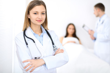 Medicine doctor standing and  smiling on the background with patient in the bed