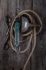 Old scissors and rope hanging on a wooden wall