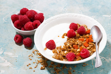 granola with dried apricots, fresh raspberries and yogurt for breakfast