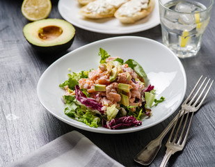 Ceviche is a traditional dish from Peru. Salmon marinated in lemon with fresh lettuce, avocado and onions