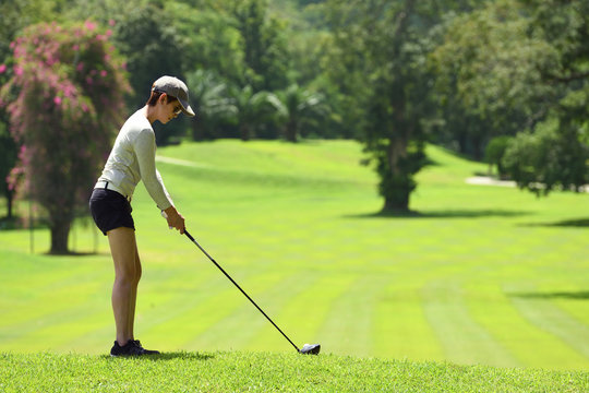  Asian woman playing golf on a beautiful natural golf course