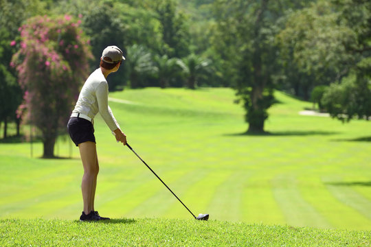 Asian woman playing golf on a beautiful natural golf course