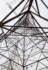 Obraz premium Energetyka. Konstrukcja wysokiej metalowej wieży przewodów elektrycznych wysokiego napięcia na tle nieba. Widok z dołu