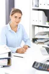 Obraz na płótnie Canvas Woman bookkeeper or financial inspector calculating or checking balance, making report. Internal Revenue Service at work with financial document. Tax and audit concept