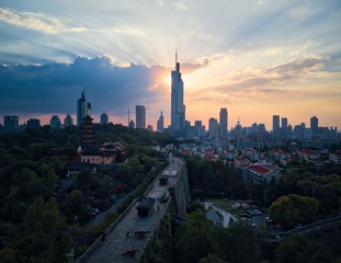Fototapeta na wymiar Sunset behind the skyscraper which is the tallest building in Nanjing city taken with a drone in the air.