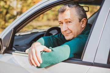 Portrait Of A Happy Mature man Driving Car To Go To Work or travels. Concept of automobile and...