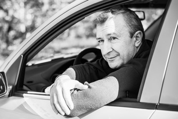 Portrait Of A Happy Mature man Driving Car To Go To Work or travels. Concept of automobile and...