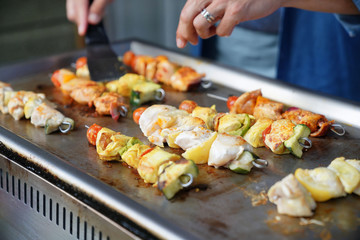 Closeup of chicken skewers cooking on grill